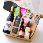 Gourmet hamper featuring Victorian Bress wine, handcrafted wine-barrel grazing board, quince paste, chocolate-coated almonds, roasted macadamias, seasoned olives, parmesan & onion biscuits, muscatel grapes, and vegan chocolate. A perfect gift for food and
