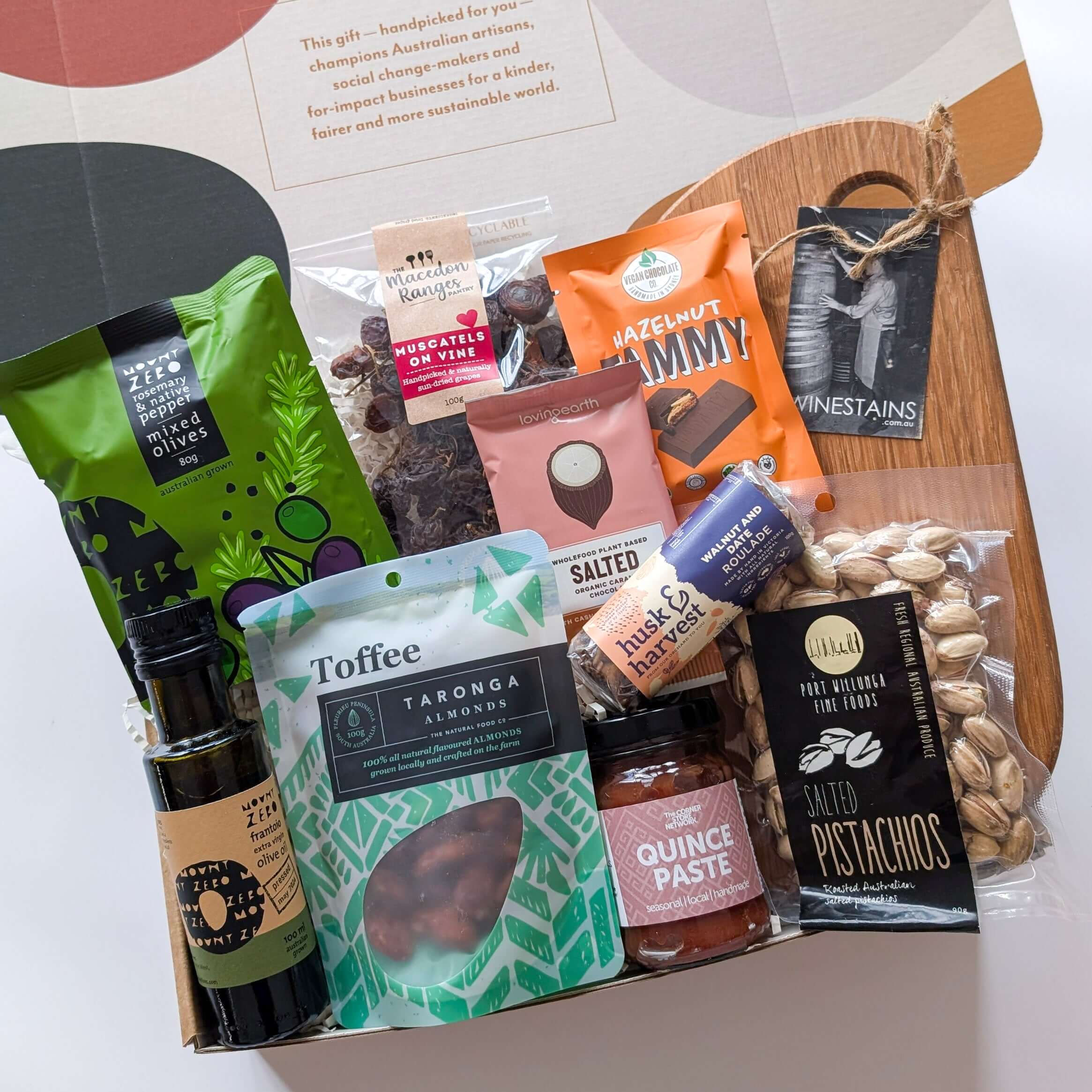 Gourmet gift basket with various food items on a white background from curated with conscience, perfect treats as a gift
