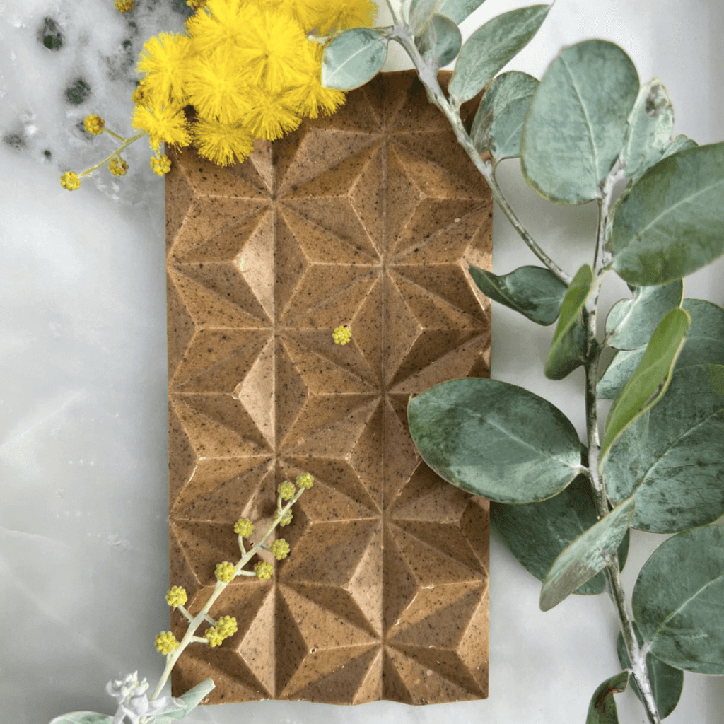 First Nations chocolatier Loco for Cocoa crafts silky milk chocolate infused with roasted wattleseed, butterscotch, and caramel toffee in the Wattle Seed Dreaming barincluded in the hamper by curated with conscience