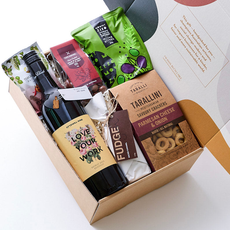 A hamper with charity-supporting Goodwill Wine, seasoned olives, recycled wine barrel wine charms, Mediterranean biscuits, salted caramel fudge, chocolate-coated fruit and nuts, and roasted macadamia. Handcrafted Australian artisan gifts.