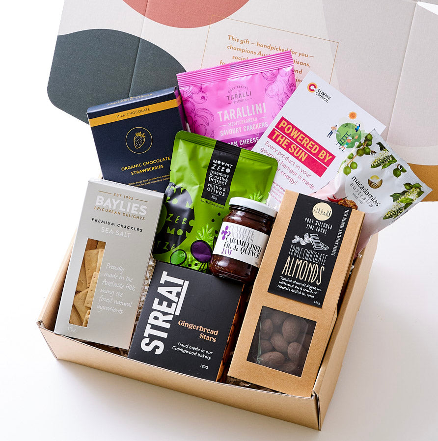 Australian gourmet hamper with artisanal treats including gingerbread stars, jams, nuts, crackers, olives, and chocolates. Sustainable and climate-friendly.