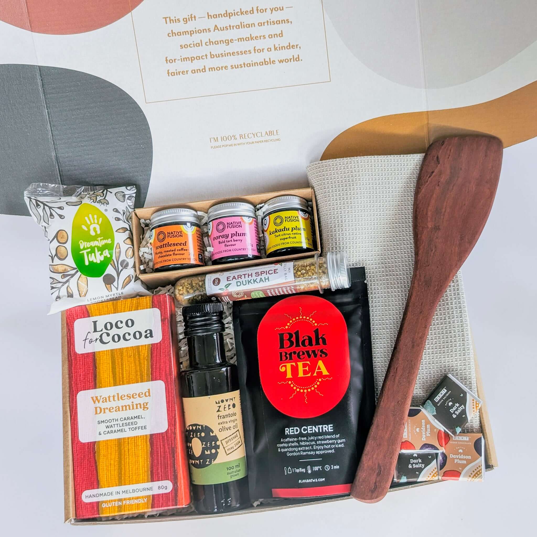 A curated collection of sustainable and Indigenous-made kitchen and pantry essentials. Includes a red gum wok spoon, organic cotton towel, native spices, Indigenous dukkah, herbal tea, wattleseed chocolate, olive oil, lemon myrtle shortbread, and vegan na