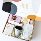 Christmas Eve self-care hamper with artisan hot chocolate, organic chai, handmade cup, biscuits, and natural skincare