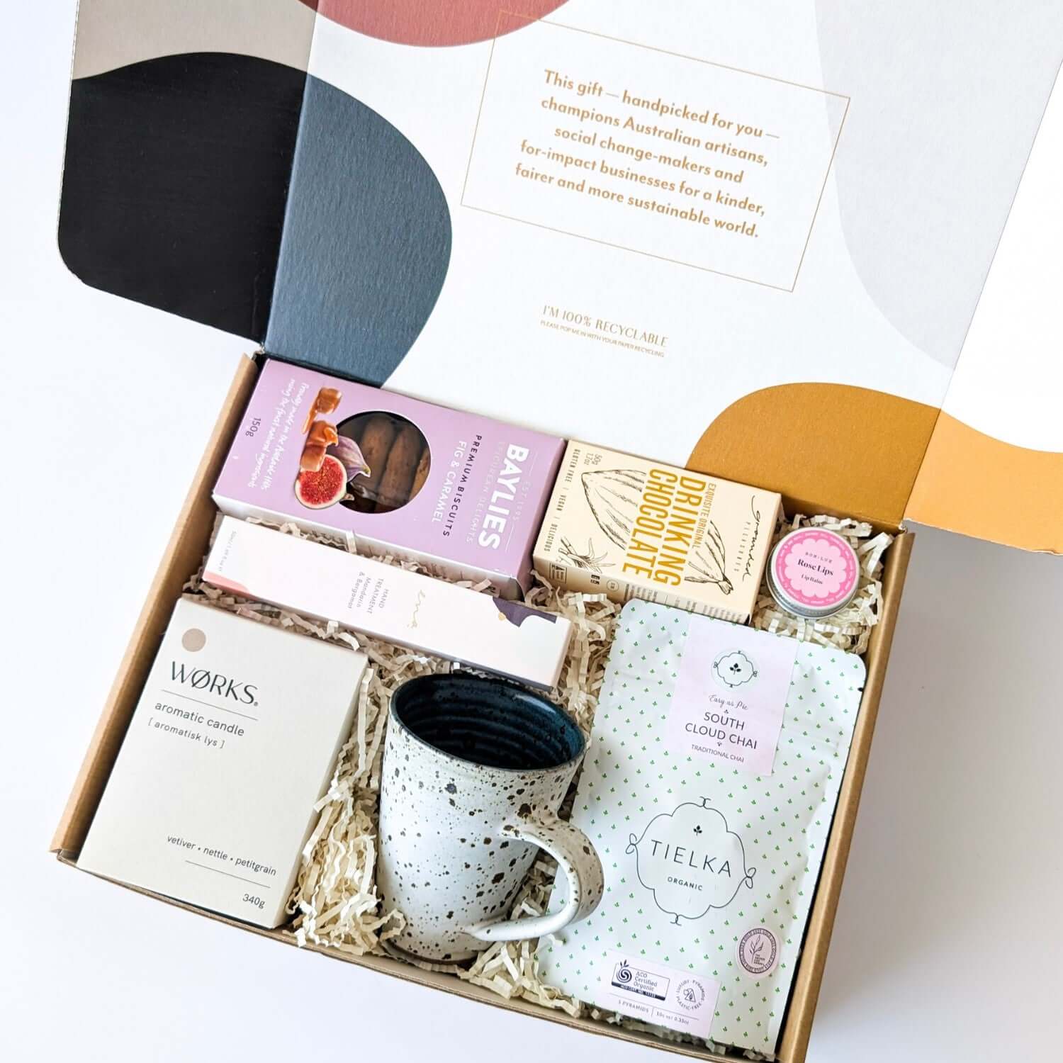 Christmas Eve self-care hamper with artisan hot chocolate, organic chai, handmade cup, biscuits, and natural skincare