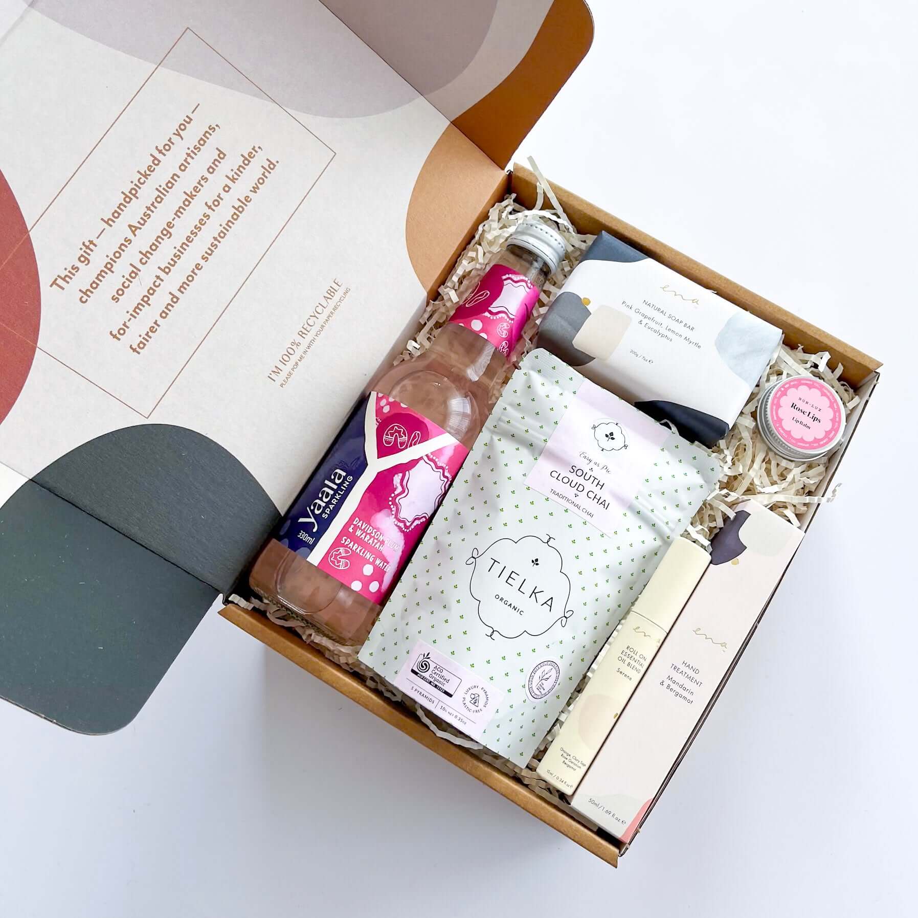 Vegan self-care hamper with Ena essential oil roll-on, Mandarin and Bergamot hand treatment, natural soap bar, organic chai tea, Indigenous-owned Yaala sparkling water, and Bon Lux rose-scented vegan lip balm.
