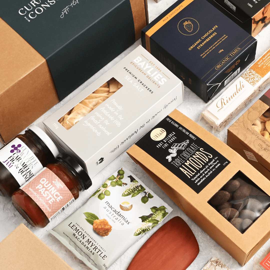 selection of gourmet hampers from Curated with Conscience featuring artisan crackers, chocolate almonds, quince paste, and lemon myrtle snacks, beautifully packed for delivery across melbourne and australia