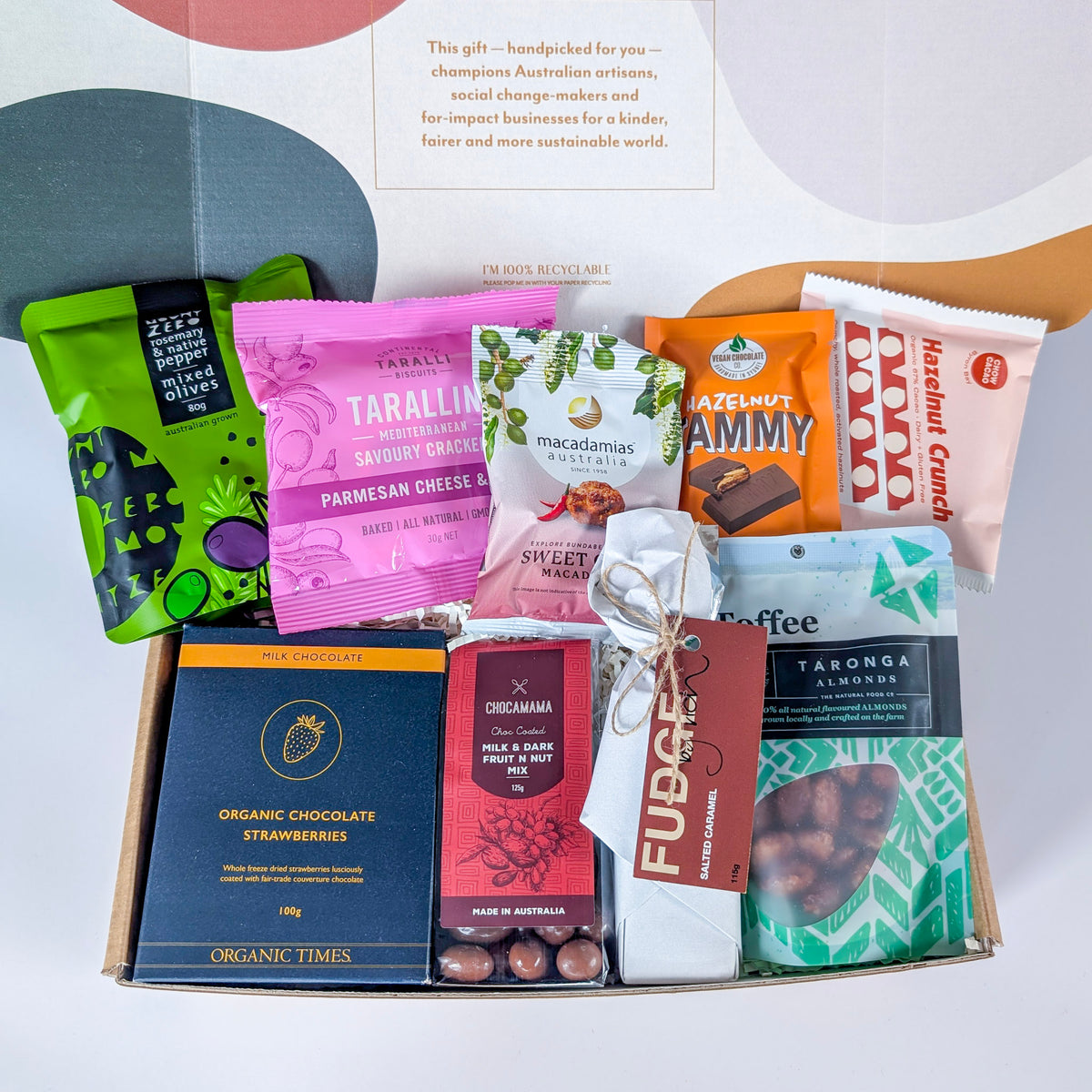 Assorted gourmet snacks in a box with visible brand names on a white background from curated with conscience, perfect for showing gratitude to someone